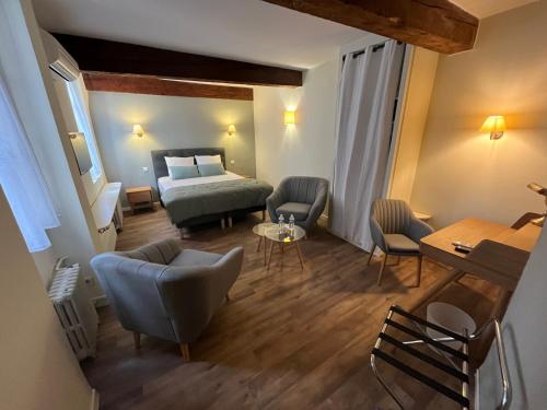 奥朗日Le Clos d'Orange, Hotel & ville de Provence的酒店客房带一张床、一张桌子和椅子