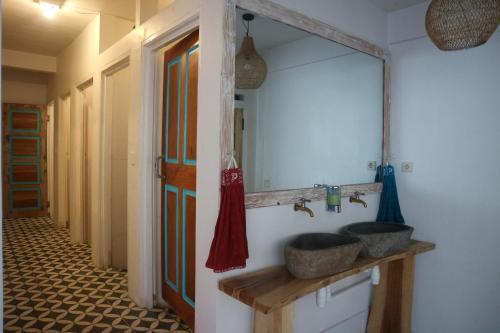 特鲁卡那拉特Lala Salama Backpacker的一间带两个盥洗盆和大镜子的浴室