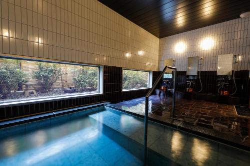IkarugaTemple Town Hotel WAQOO Horyuji的一座带大窗户的建筑中的游泳池