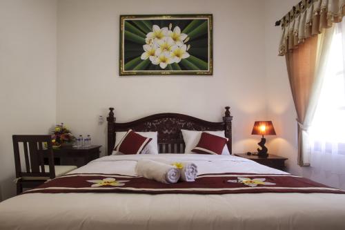 努沙杜瓦素馨民宿的卧室配有一张挂着花卉图案的床。