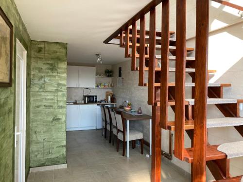 IrigFruška Gora Guesthouse的一间厨房和带木制螺旋楼梯的用餐室