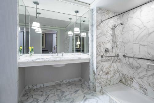 克莱顿圣路易斯丽思卡尔顿酒店的白色的浴室设有水槽和淋浴。