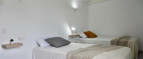 科洛尼亚圣霍尔迪维维茵玛格丽塔II酒店的一间白色客房,房间内设有两张床