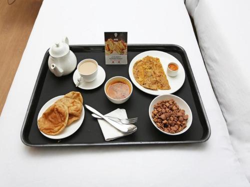 德瓦尔卡The Sky Comfort Hotel Parth Inn的床上的托盘食物和早餐食品