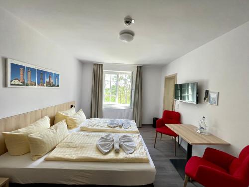 普雷罗Ferienhotel Alter Bahnhof garni的酒店客房带两张床和一张桌子以及椅子。