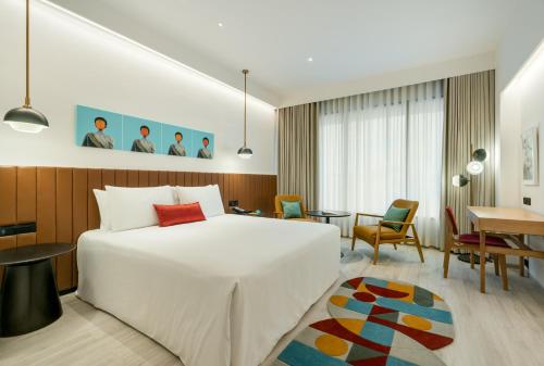 班加罗尔Greenpark Bengaluru的一间酒店客房,配有一张白色的床和一张书桌