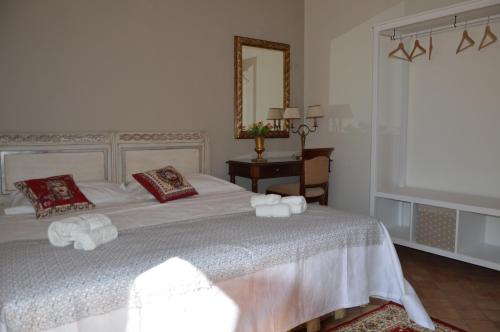 马斯卡卢恰Uzeda, Doppia con bagno privato的卧室配有白色的床和镜子