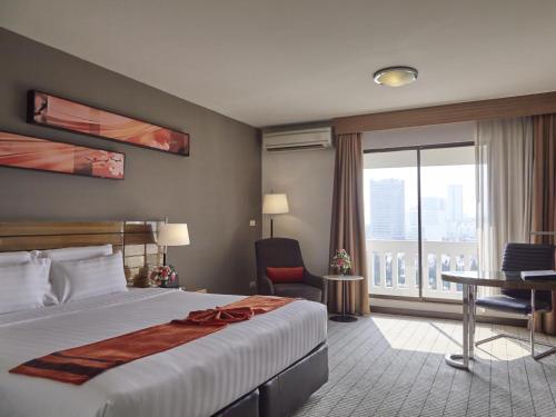 曼谷枫叶酒店的配有一张床、一张书桌和一扇窗户的酒店客房