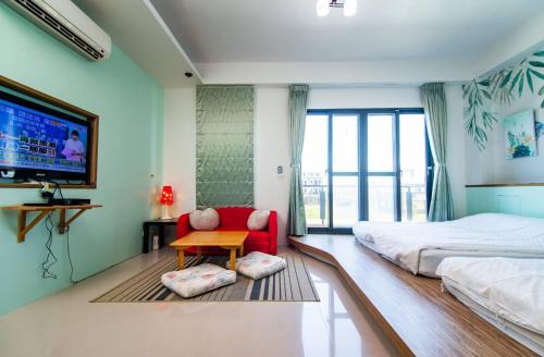 头城闲闲的海的一间卧室配有一张床、一张红色椅子和一台电视。