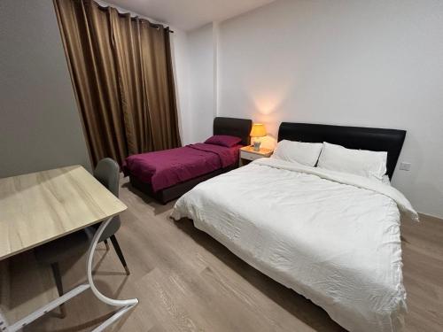 古晋Armadale Residence-Gala City的一间卧室配有一张床、一张桌子和一张四柱床。