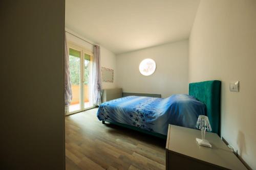 蒂勒尼亚Residence San Francesco的一间卧室配有一张带蓝色床罩的床和窗户。