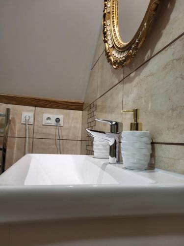 帕兰加Vila Florena的浴室设有白色水槽和镜子