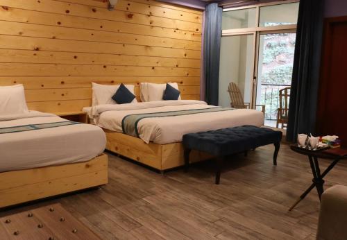 纳兰恩Snow Crest Lodges的一间卧室设有两张床和木墙