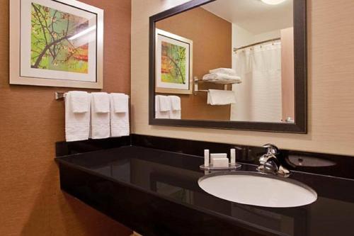 塔尔萨Fairfield Inn & Suites Tulsa South Medical District的浴室配有盥洗盆、镜子和毛巾