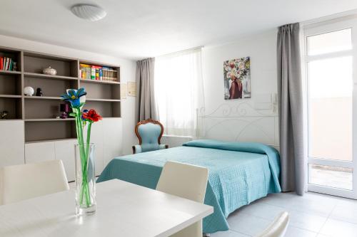福洛尼卡CAMPI ALTI AL MARE APARTMENTS的一间卧室,配有一张床和一张花瓶上的桌子