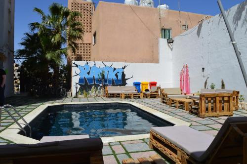 瓦迪穆萨Rafiki Hostel的一座带椅子的庭院和一座建筑中的游泳池