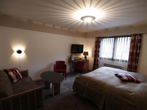 斯科平罗尔德斯托克酒店的酒店客房配有床、沙发和桌子。