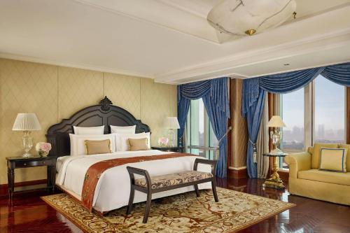 广州广州富力丽思卡尔顿酒店的一间卧室设有一张大床、一把椅子和窗户。