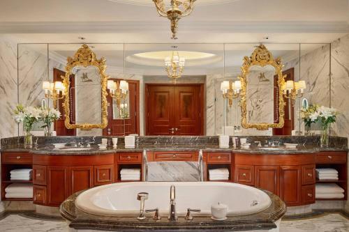 广州The Ritz-Carlton, Guangzhou的带浴缸、两个盥洗盆和镜子的浴室