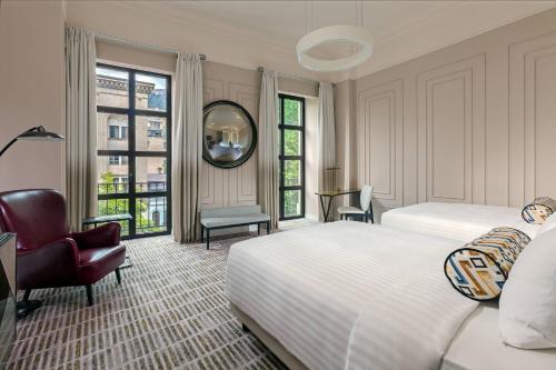 第比利斯第比利斯万豪酒店的一间卧室配有两张床、一把椅子和镜子