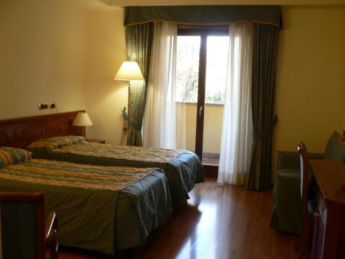 韦莱特里贝尼托阿尔博斯科酒店的酒店客房设有两张床和窗户。