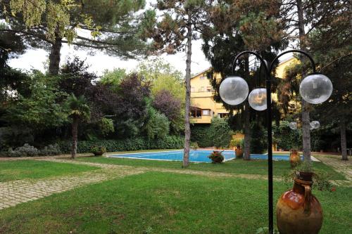韦莱特里贝尼托阿尔博斯科酒店的一个带游泳池的院子内的灯