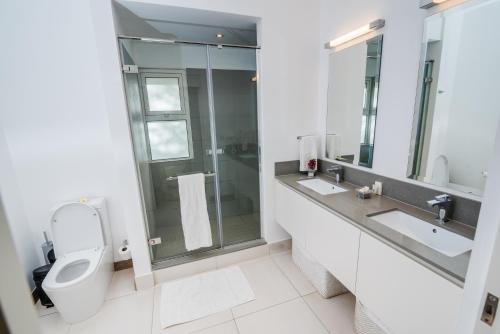 埃斯尼角Summer Breeze - Beachfront - 3 Bedrooms Suite的浴室配有卫生间、两个盥洗盆和淋浴。