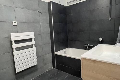 博尼法乔D24- T3-Les Hauts du Port-parking-clim-wifi-50m du port的浴室配有盥洗盆和浴缸。