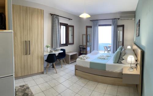 赛罗卡波斯Asteras Apartments的卧室配有一张床和一张桌子及椅子