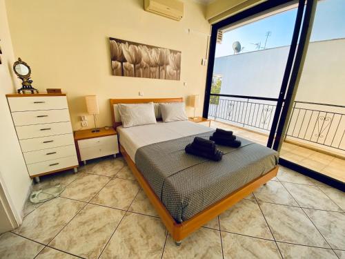 阿马利阿斯Sunny Apartment Amaliada的一间卧室设有一张床和一个大窗户