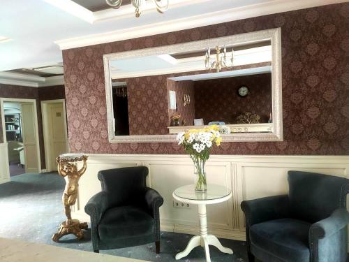 基希讷乌Savoy Hotel的客厅配有两把椅子和一张带镜子的桌子