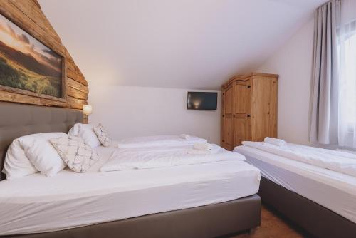 滨湖采尔Chalet Badia by we rent, SUMMERCARD INCLUDED的白色墙壁客房的两张床