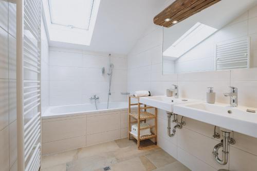 滨湖采尔Chalet Badia by we rent, SUMMERCARD INCLUDED的白色的浴室设有2个盥洗盆和1个浴缸。