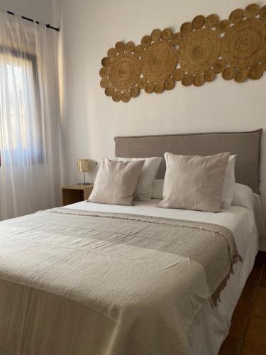 博罗尼亚Habitaciones Carmencita的卧室配有一张带白色床单和枕头的大床。