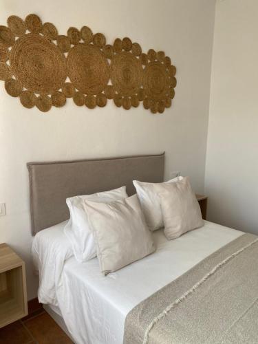 博罗尼亚Habitaciones Carmencita的一间卧室配有带白色床单和枕头的床。