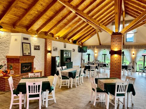 GhimeşBiotour Camping & Restaurant的一间带桌椅和壁炉的用餐室