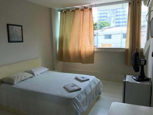 萨尔瓦多Hotel Minas Salvador的一间卧室配有一张床,上面有两条毛巾