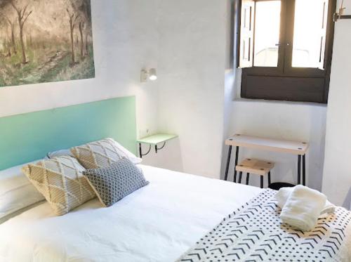 加尔达尔Casa El Terrero的卧室配有带枕头的白色床和窗户。