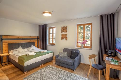 瓦尔季采Resort Valtberg Valtice的一间卧室配有一张床、一把椅子和电视