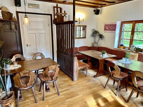 福森Pension Steakhaus Füssen的用餐室配有木桌和椅子