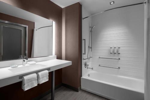 圣安东尼奥AC Hotel by Marriott San Antonio Riverwalk的浴室配有白色水槽和淋浴。