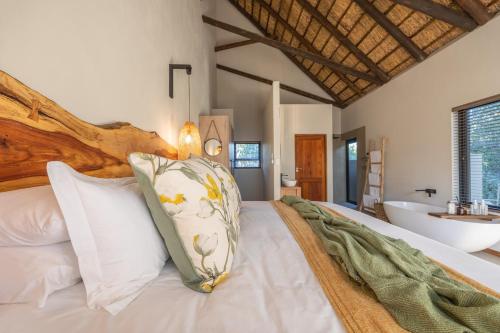 侯斯普瑞特Ukanyi Luxury Villa的一间卧室配有一张带水槽和浴缸的床