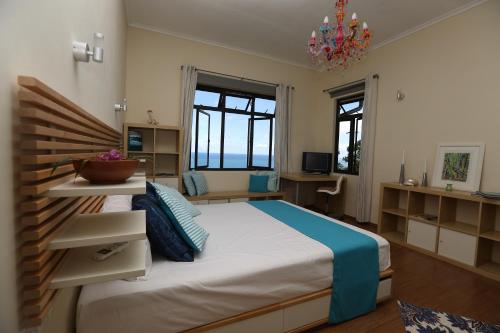 博瓦隆拉维别墅的一间卧室配有一张大床和一个吊灯。