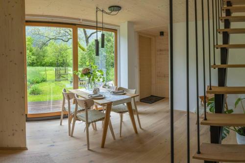 博维茨Tiny Eko House Bovec的一间带桌椅和大窗户的用餐室