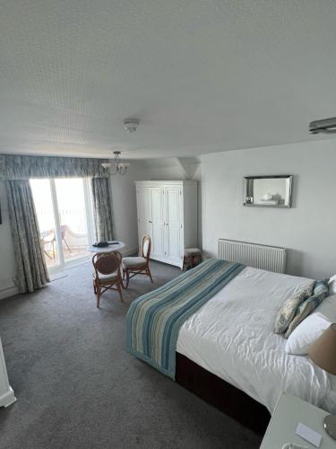 西卢港汉纳福尔波因特酒店的一间卧室配有一张床、一张桌子和一张桌子