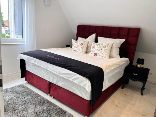 居特斯洛RelaxDays-Apartments的卧室里一张红色床头的床