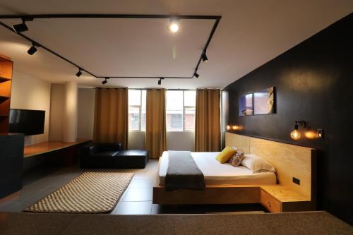 卡利554 Apartments的一间卧室配有一张床、一张沙发和一台电视