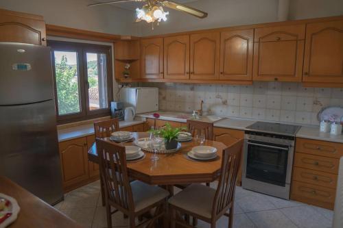 卡兰巴卡Villa Nefeli的厨房配有桌椅和冰箱。