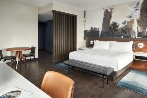 奥因斯米尔斯Marriott Owings Mills Metro Centre的酒店客房带一张床、一张桌子和椅子