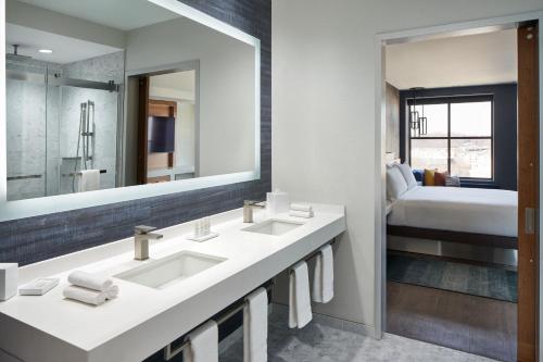 奥因斯米尔斯Marriott Owings Mills Metro Centre的一间带两个盥洗盆和大镜子的浴室